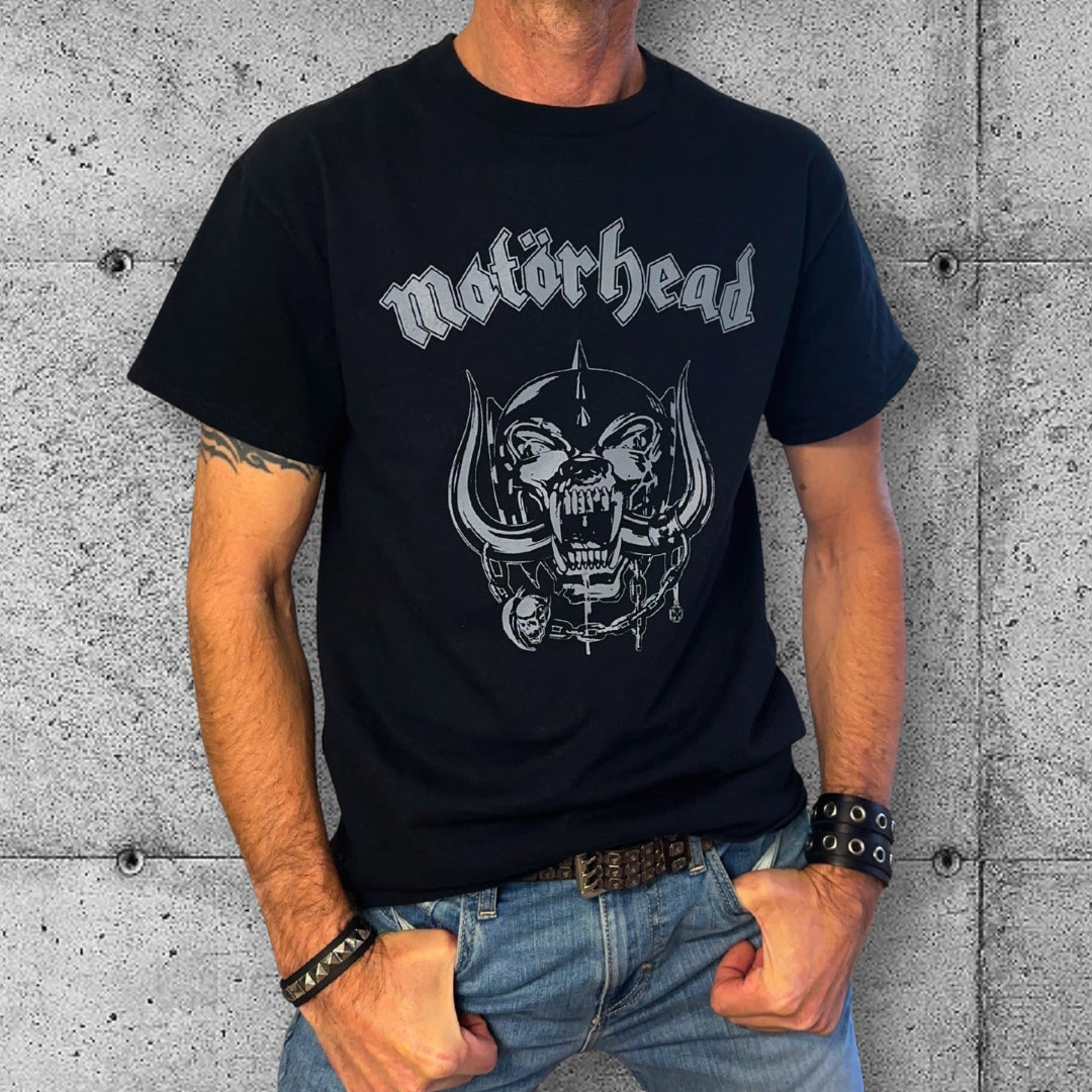 Man wearing black Motörhead logo t-shirt, punk rocker clothing, against concrete wall