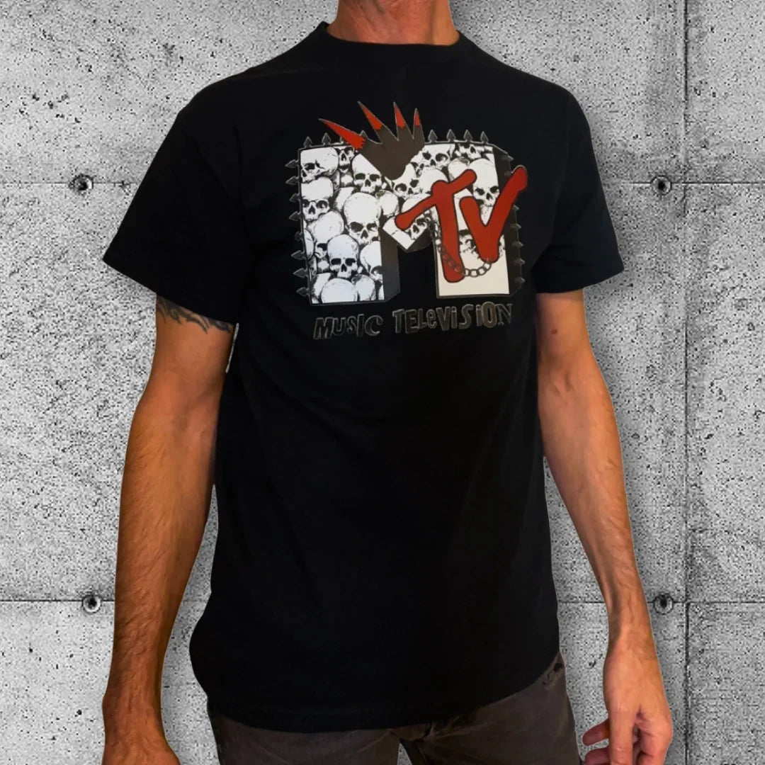 Man wearing black punk rock t-shirt with gothic MTV parody skull pile graphic