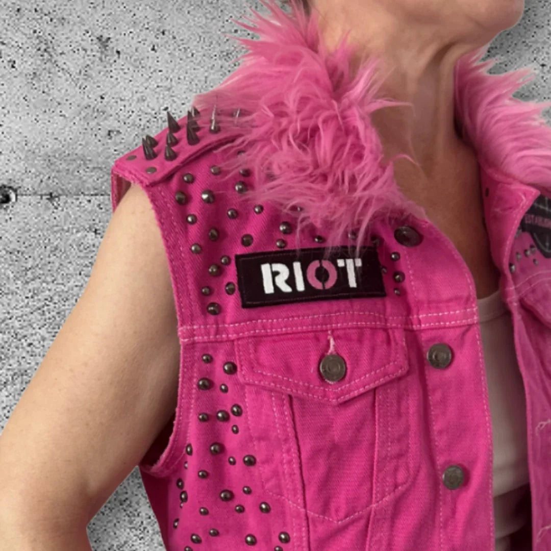 Women's pink punk vest with spikes, studs, faux fur collar, and RIOT patch