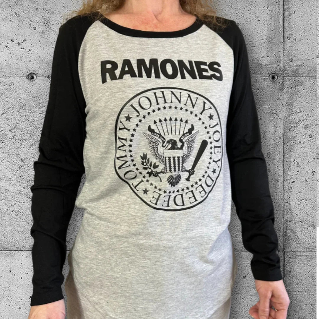 Woman wearing women's Ramones raglan tee, punk rocker shirt with black sleeves, concrete background