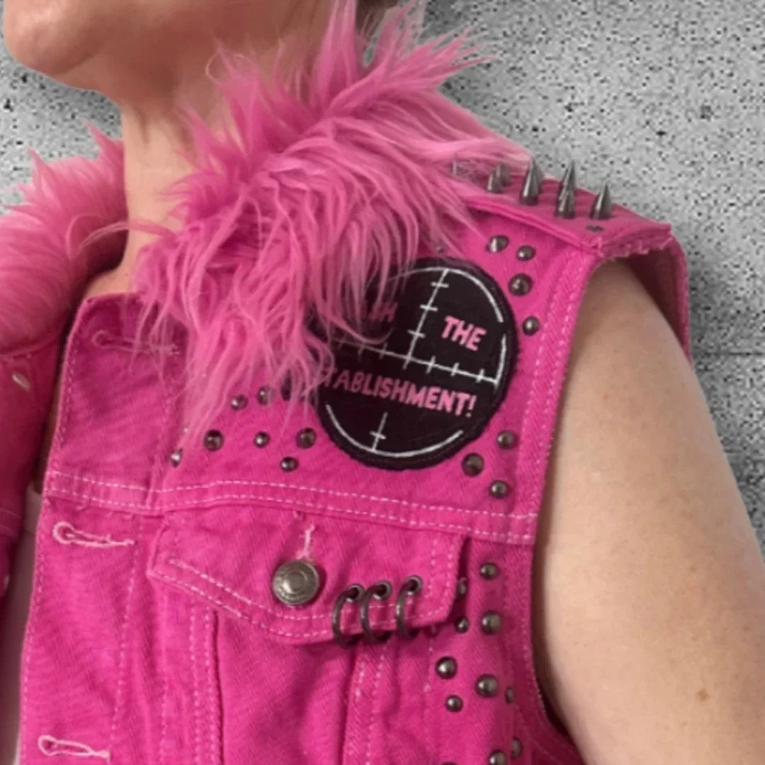Pink punk vest with spikes, studs, and 'Fuck the Establishment' patch, featuring feather collar detail.