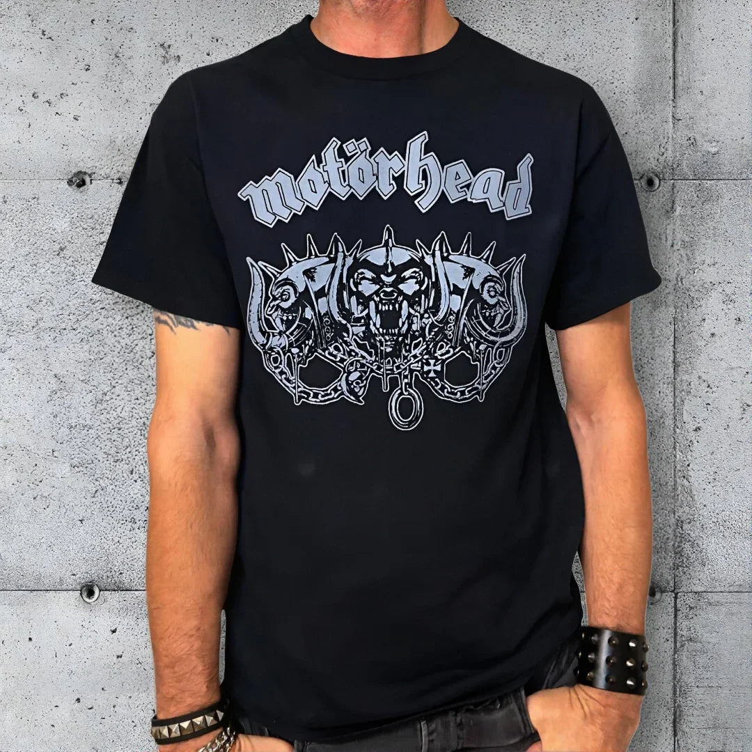 Man wearing a black Motörhead three-headed warpig graphic rock t-shirt against concrete wall