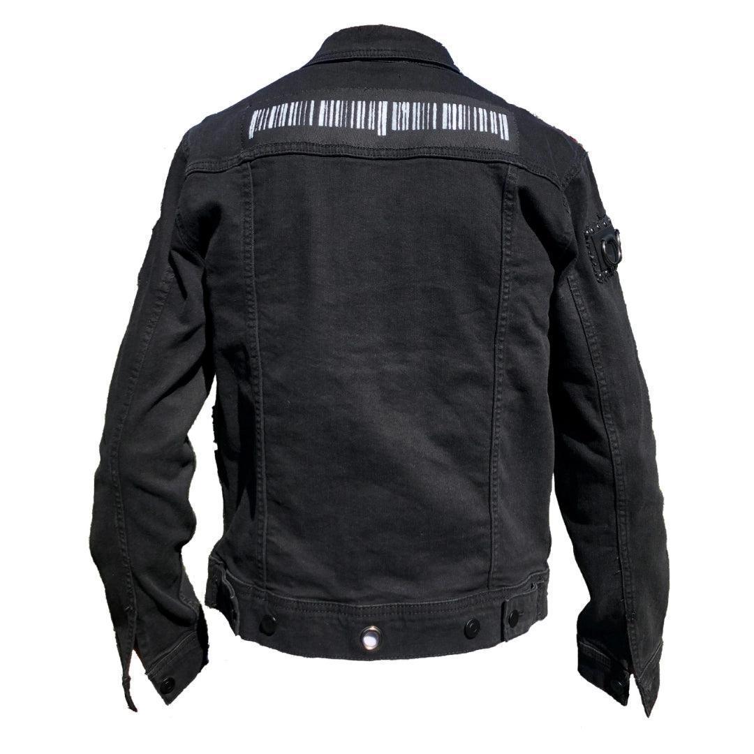 Back view of a punk- inspired black denim jacket featuring a light grey painted bar code patch across the upper back and metal grommets lining the jacket hem. Perfect for punk rock fashion enthusiasts.