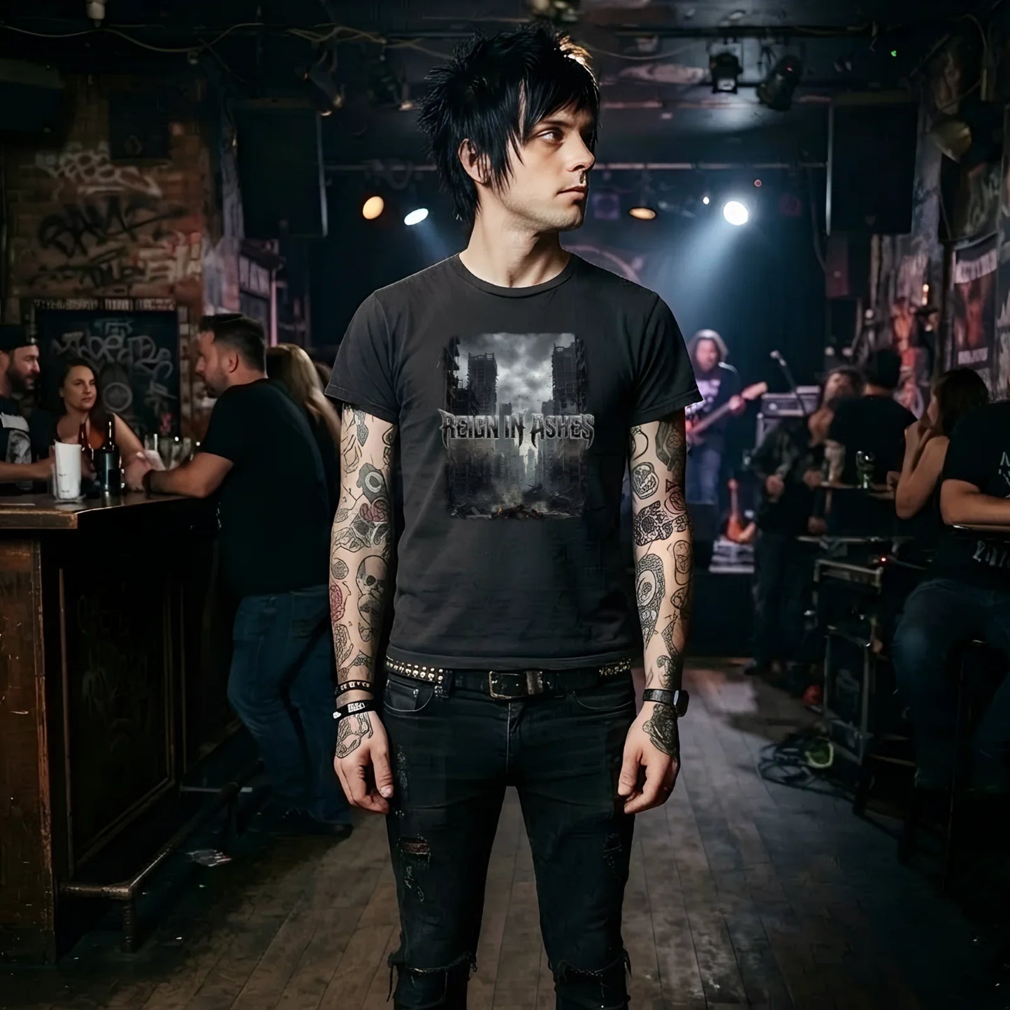 Man in punk rock t-shirt with 'Reign in Ashes' graphic, tattoos, ripped jeans at live music venue