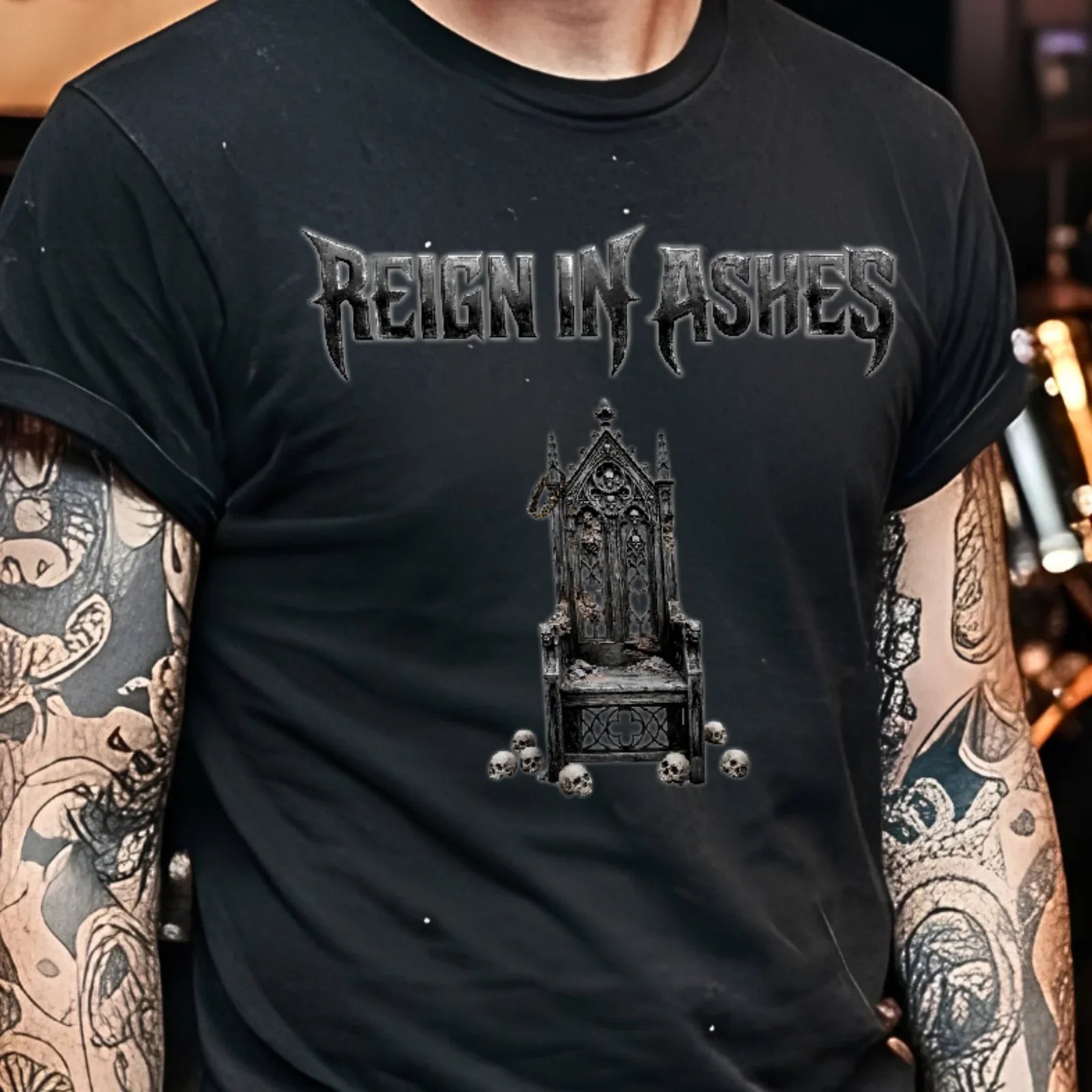 Black punk t-shirt with 'Reign in Ashes' gothic throne graphic, skulls, worn by tattooed person