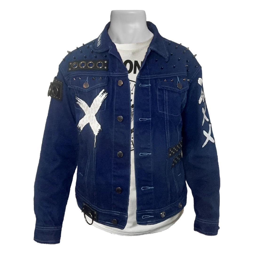 Royal Blue denim jacket with punk-inspired design, featuring round head studs on the shoulders, a white 'X' painted on the left side upper pocket, and two black leather strips with gunmetal studs on the lower left side.