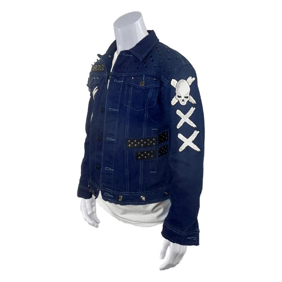 Left side view of royal blue punk-style denim jacket featuring skull and cross bones designed patches, black leather straps with metal studs, and two white painted 'X'  on the sleeve. Perfect for alternative fashion enthusiasts.