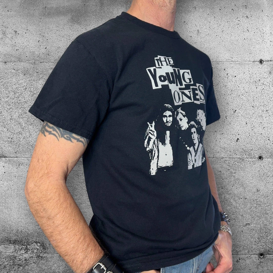 Man wearing black The Young Ones punk t-shirt with band graphic against concrete wall