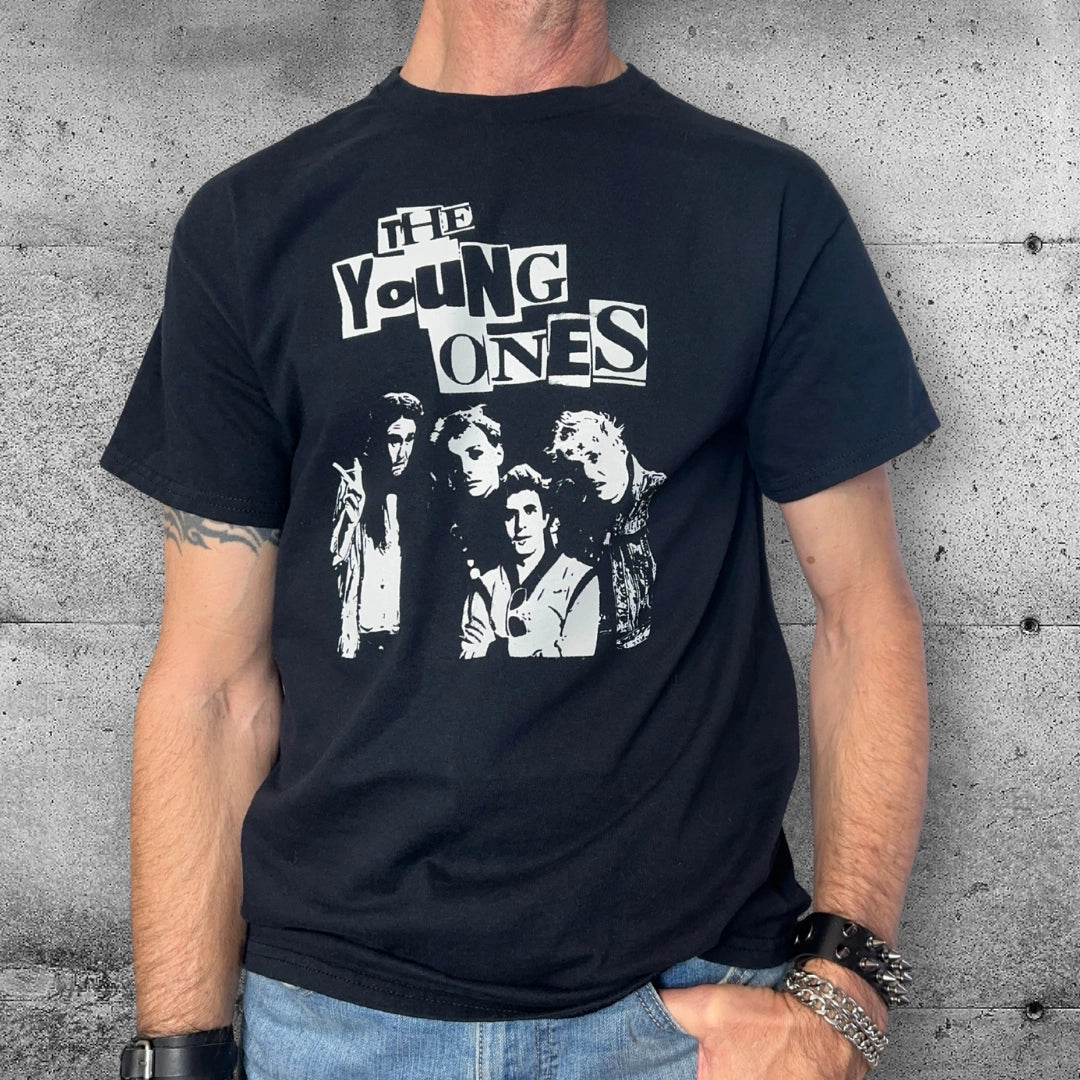 Man wearing black The Young Ones punk t-shirt with band graphic, rocker accessories, concrete wall